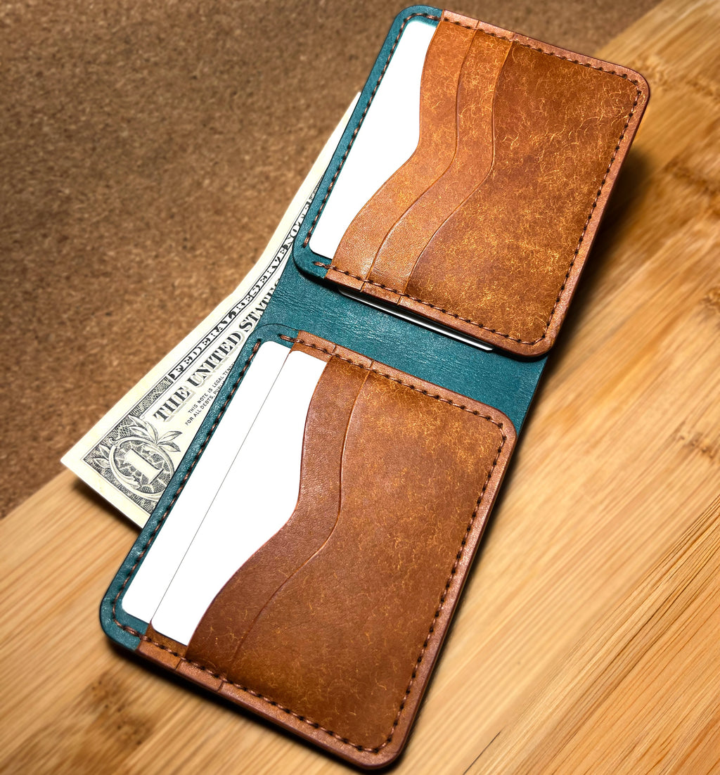 Brown leather wallet with teal interior on a wooden surface