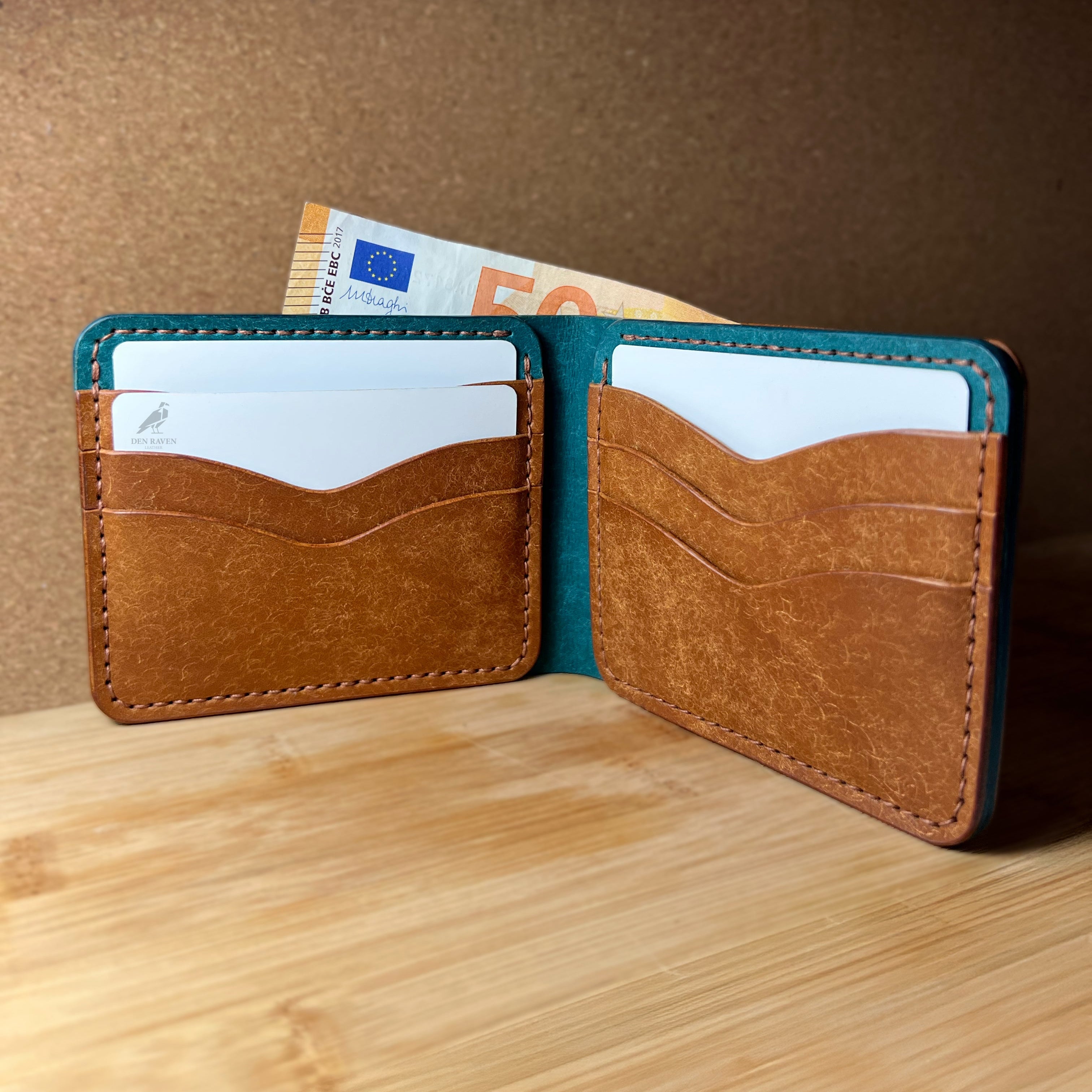 Open leather wallet with cards and money on a wooden surface and brown background