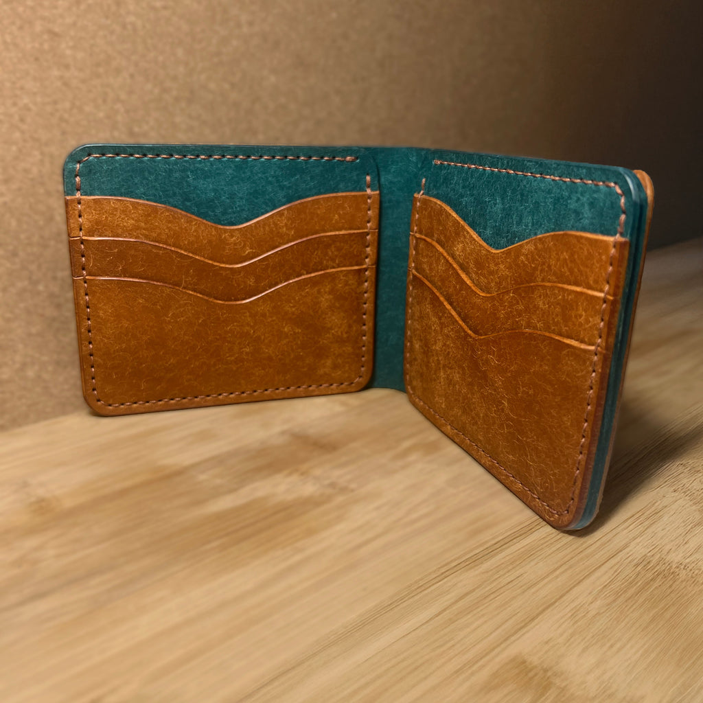 Two-tone leather wallet with blue and brown sections on a wooden surface.