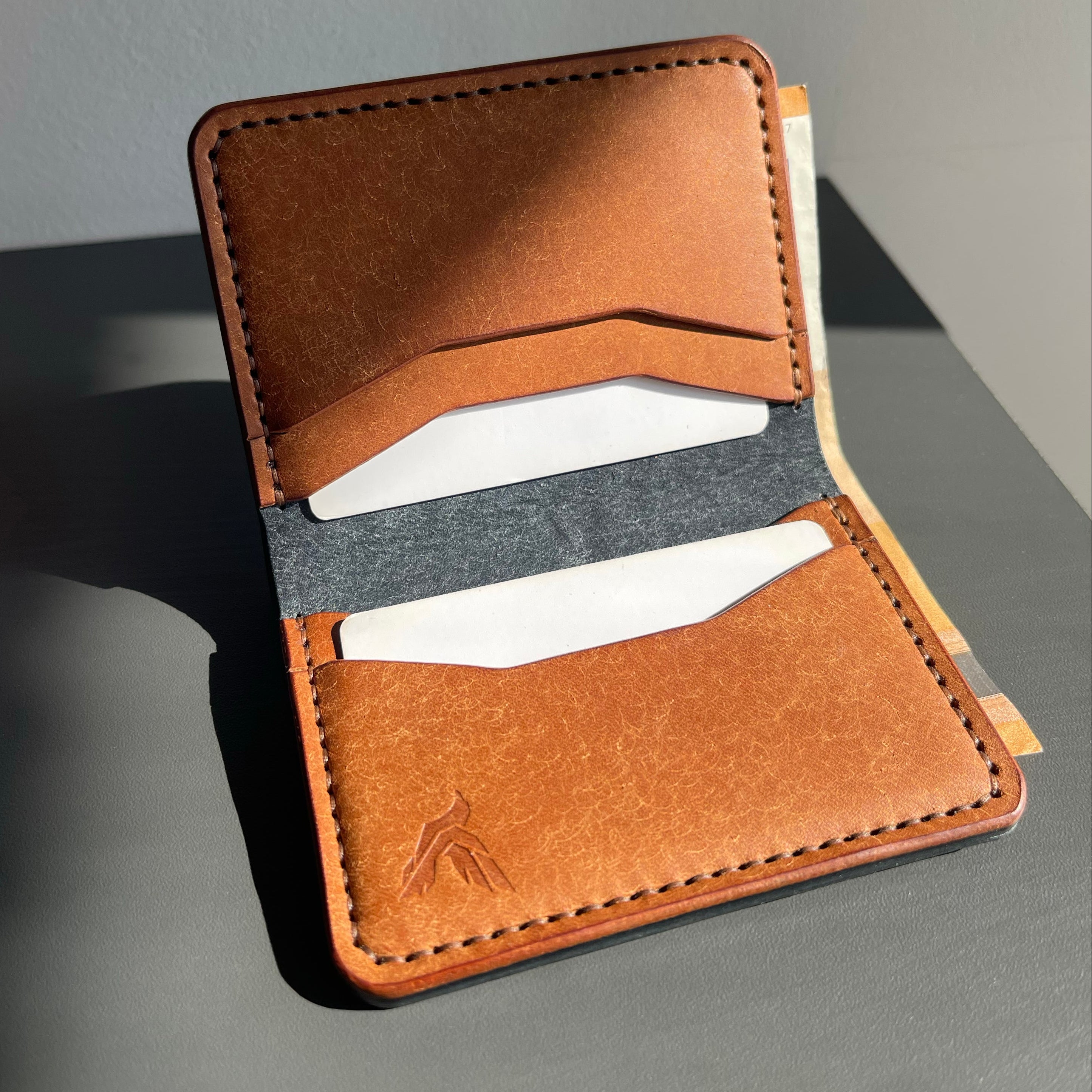 Brown leather wallet with card slots on a gray surface