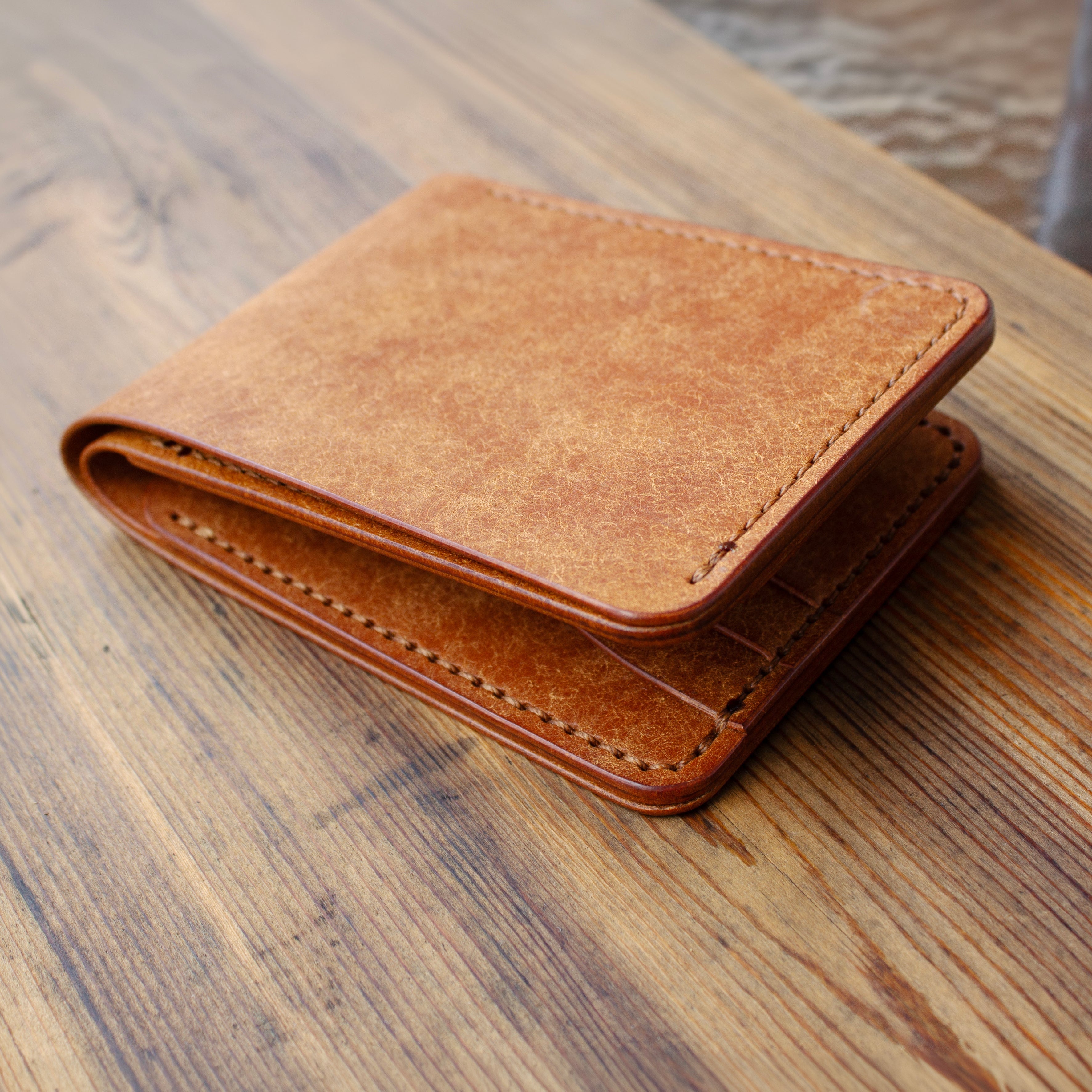 Brown leather wallet on a wooden surface