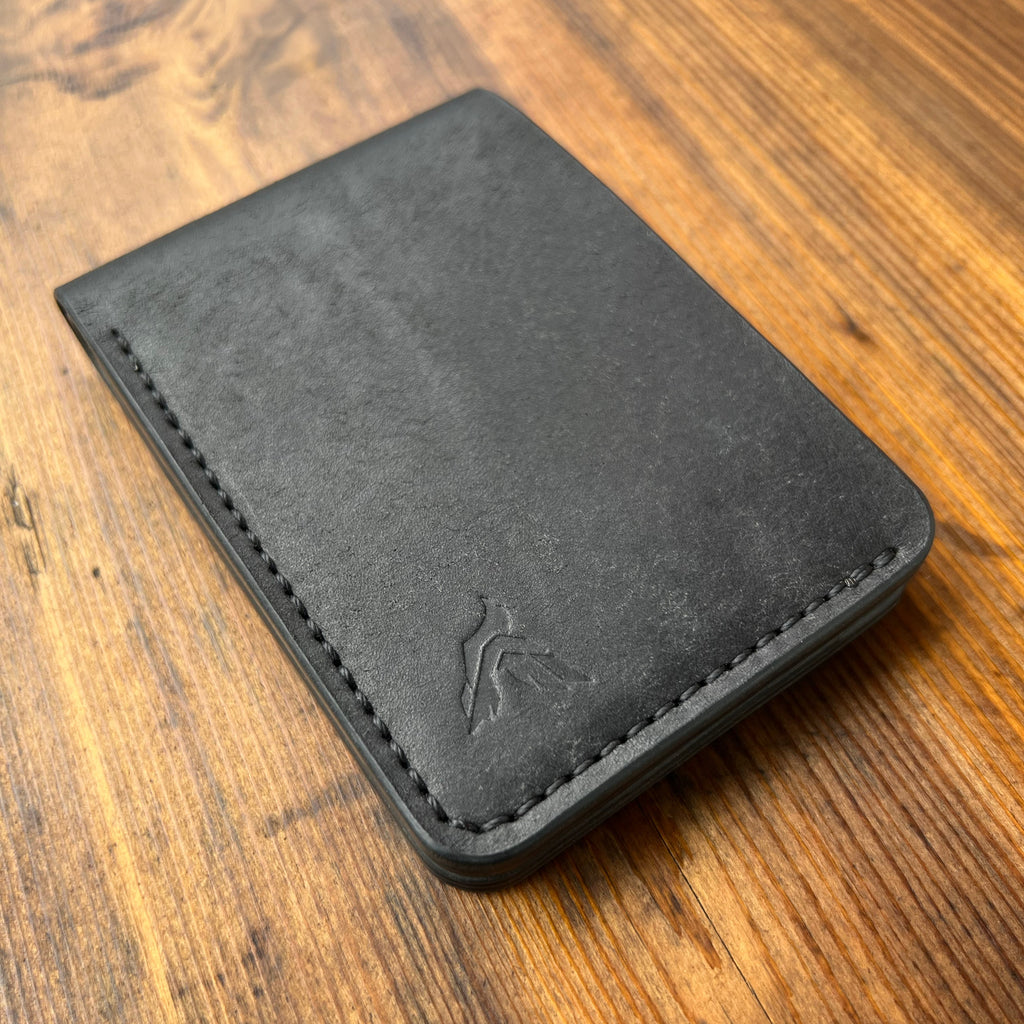 Black leather wallet on a wooden surface