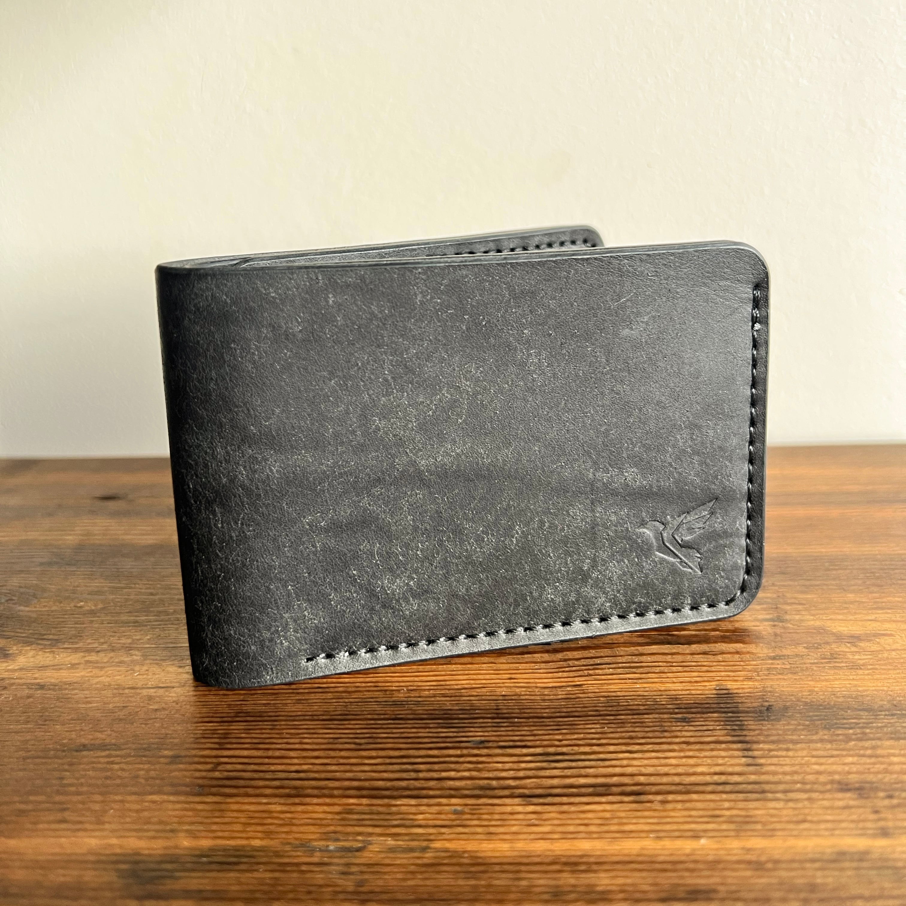 Gray wallet on a wooden surface with a beige background