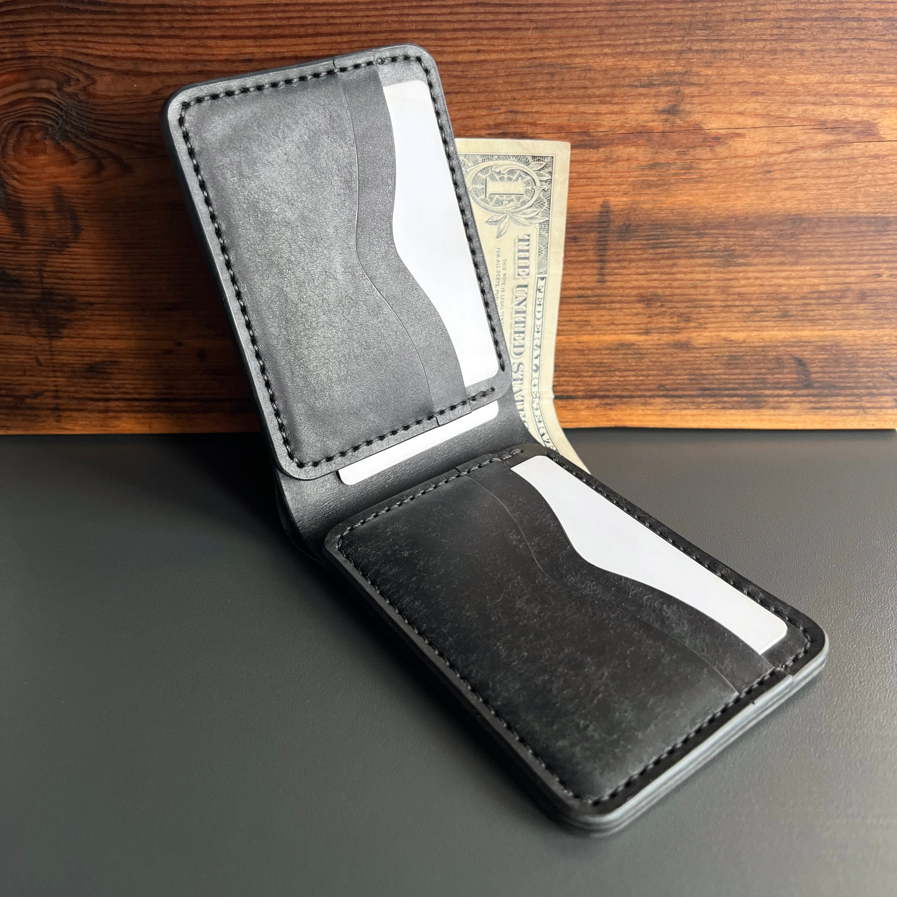 Black leather wallet with card slots on a wooden surface