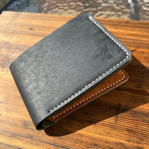 Two-tone leather wallet on a wooden surface
