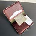 Brown leather wallet with card slots on a gray surface