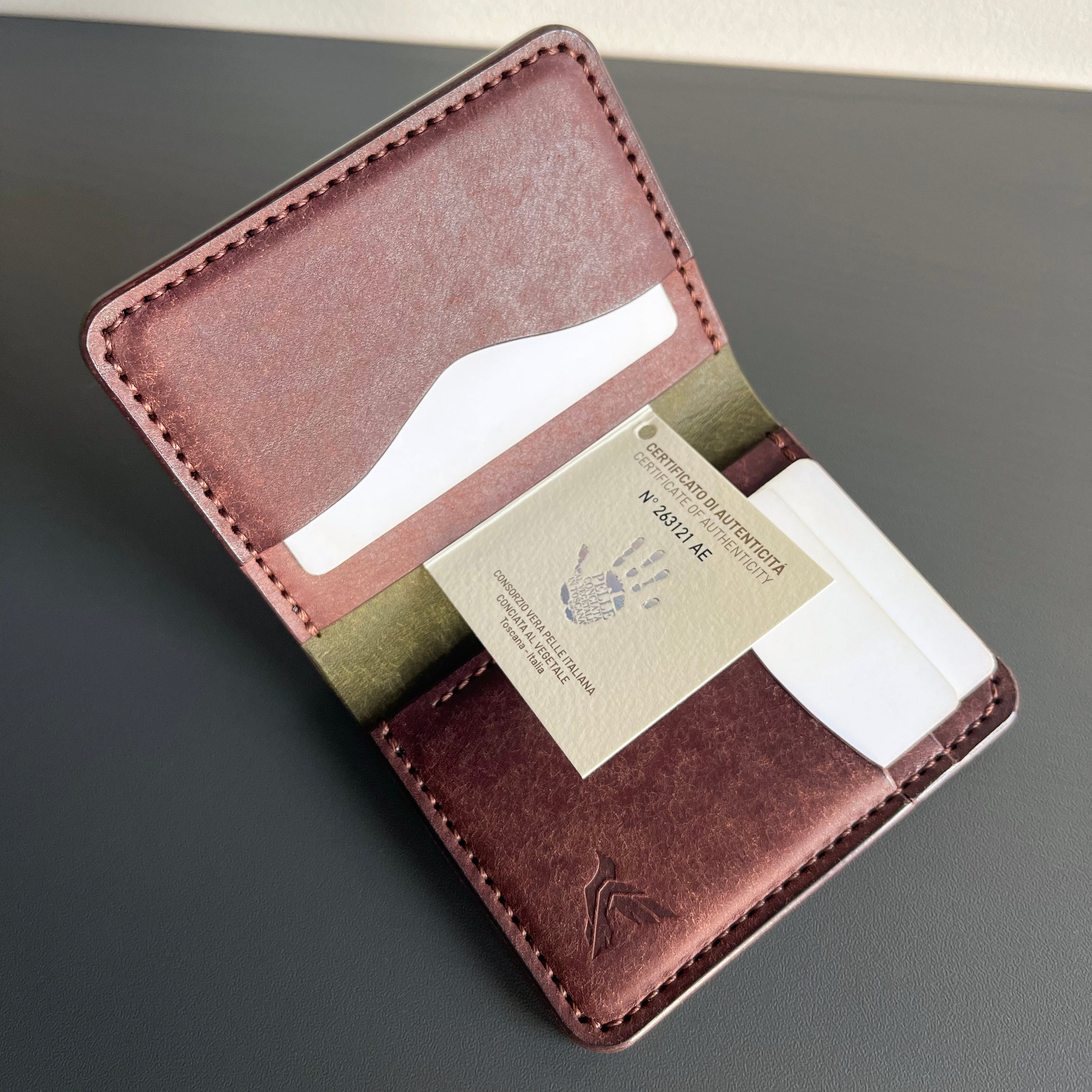 Brown leather wallet with card slots on a gray surface