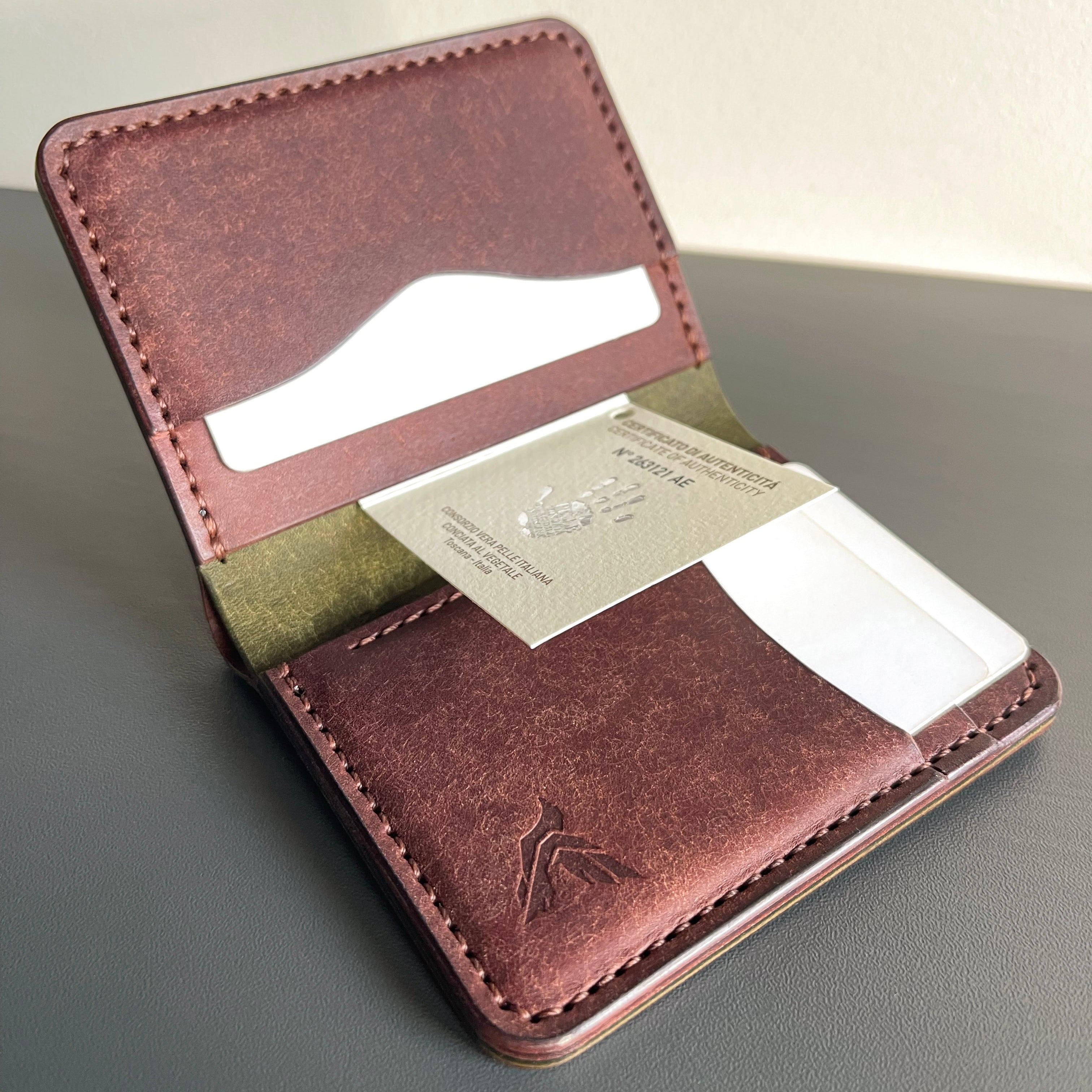 Brown leather wallet with card slots on a gray surface