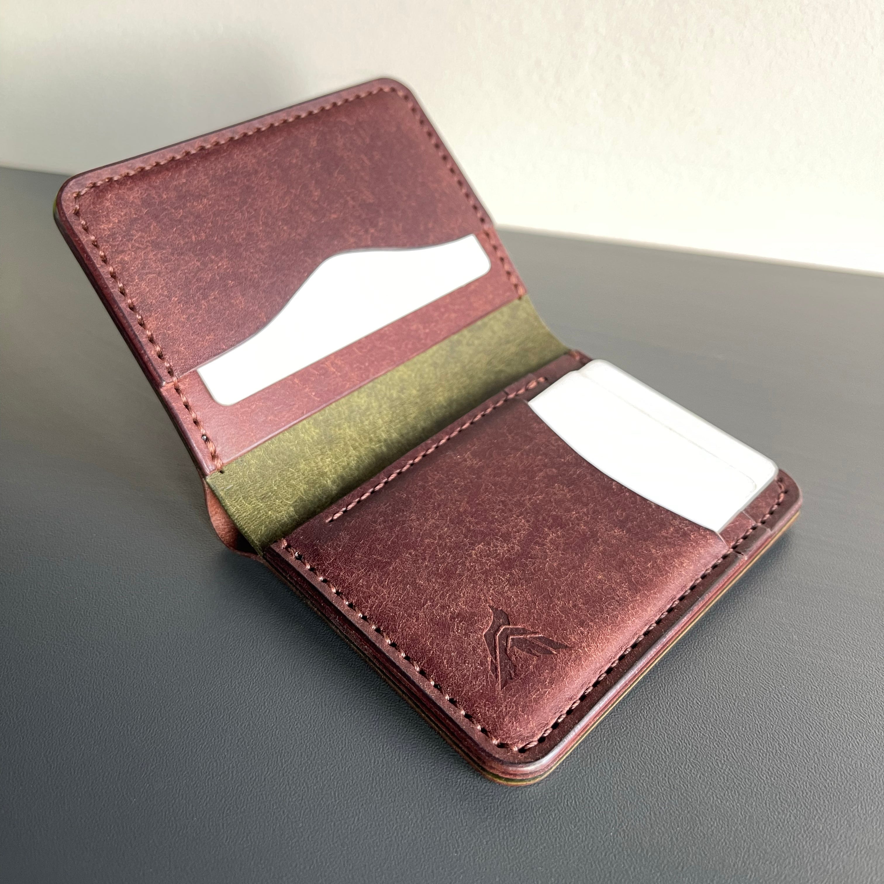 Brown leather wallet with card slots on a gray surface