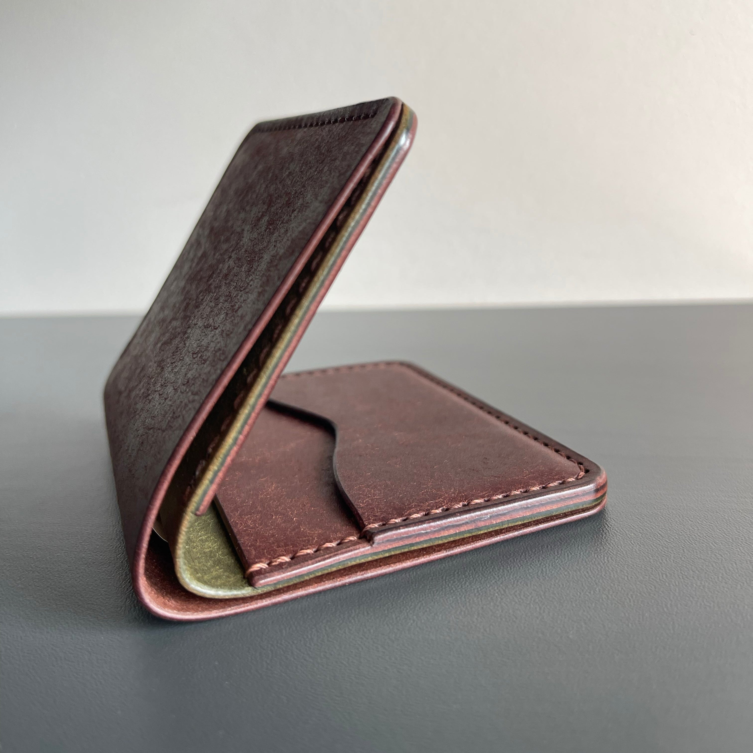 Brown leather wallet on a gray surface with a light gray background