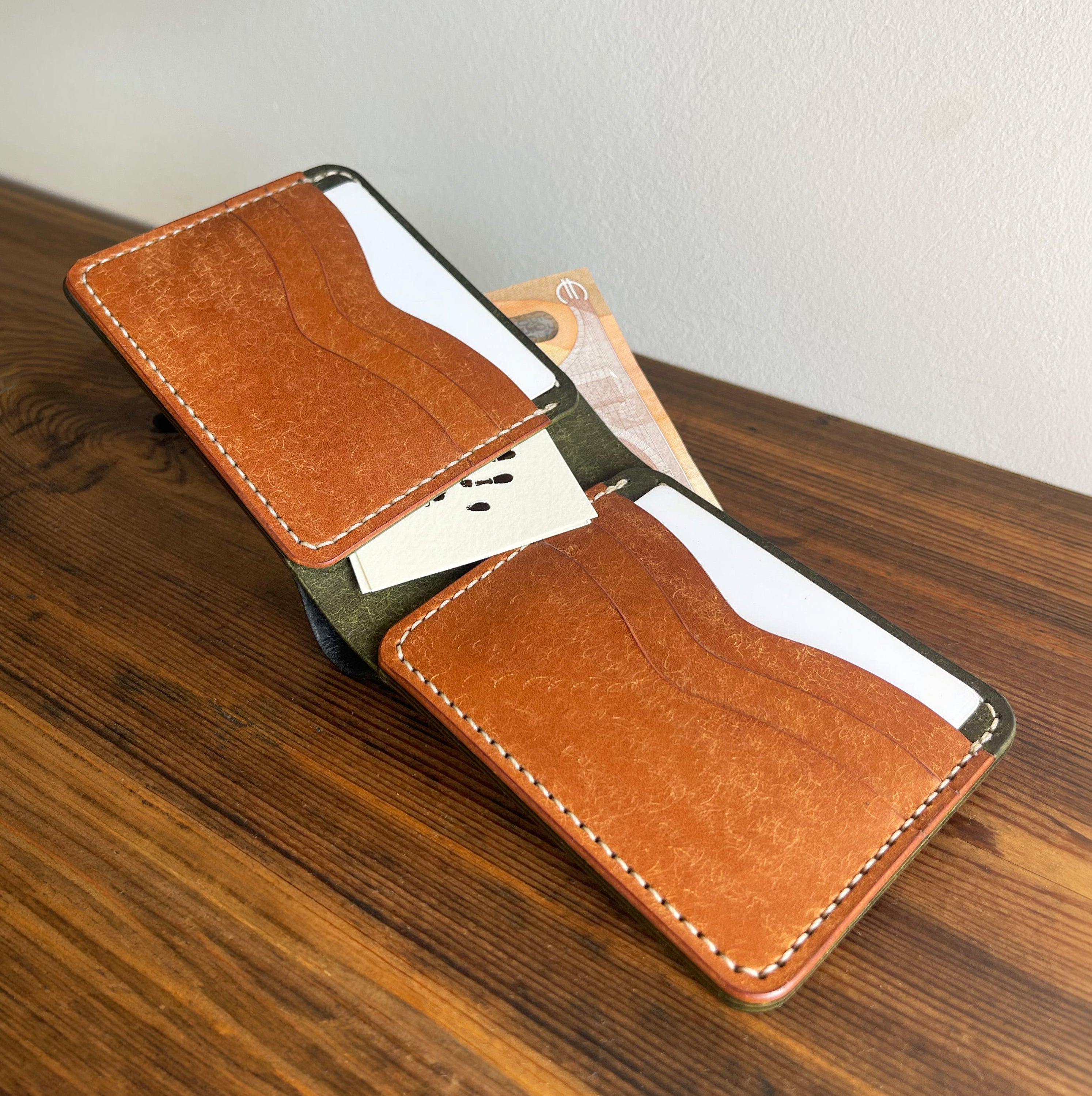 Brown leather phone case on a wooden surface with a neutral background