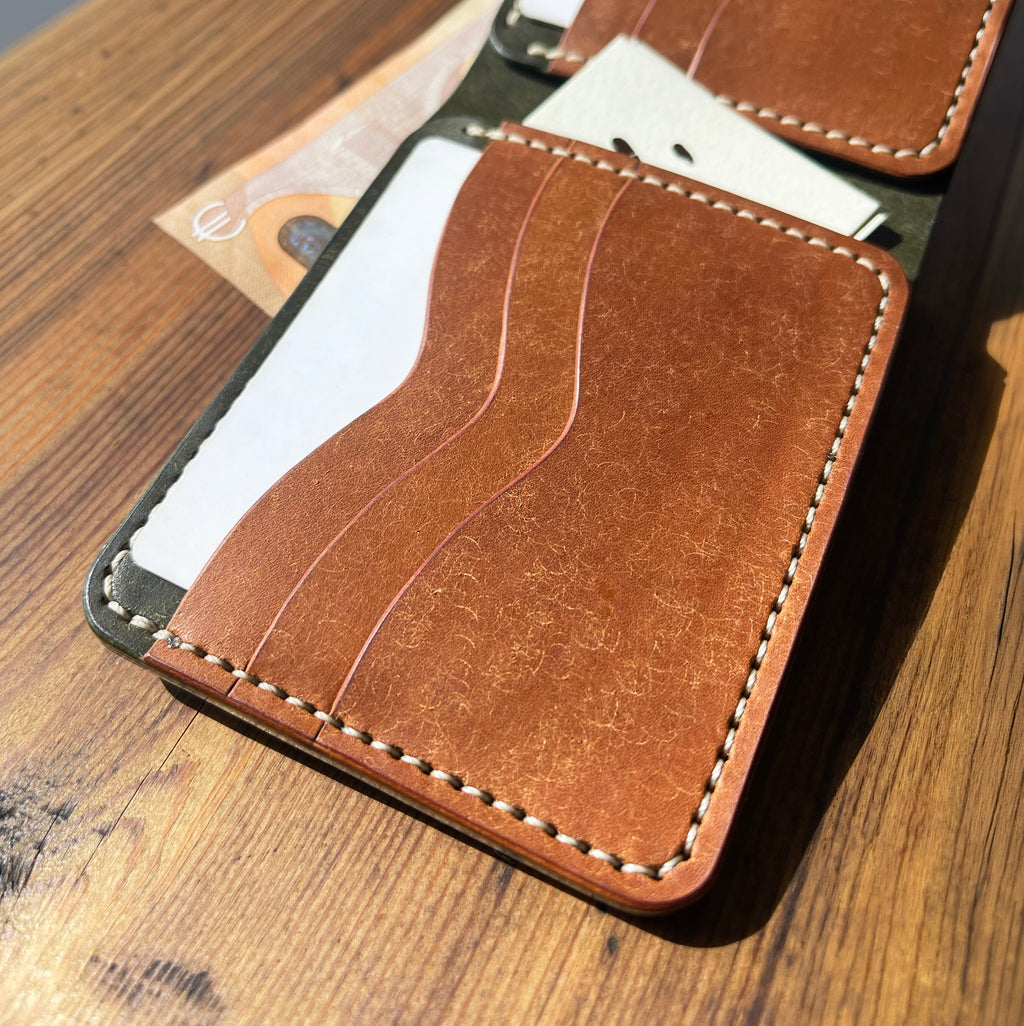 Brown leather wallet with card slots on a wooden surface