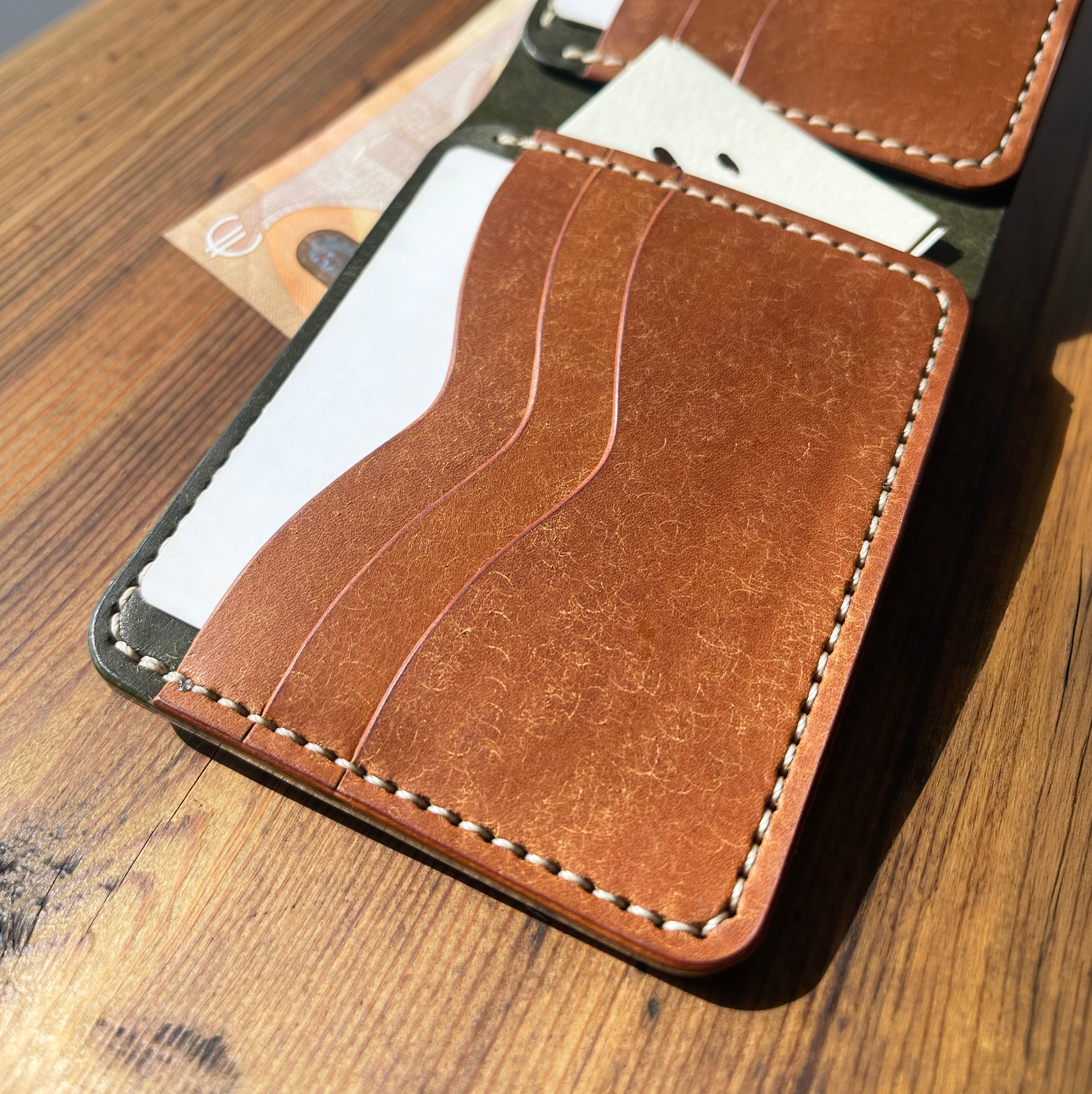 Brown leather wallet with card slots on a wooden surface
