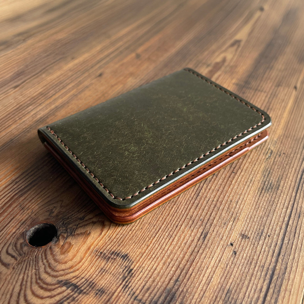 Green leather wallet on a wooden surface