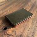 Green leather wallet on a wooden surface