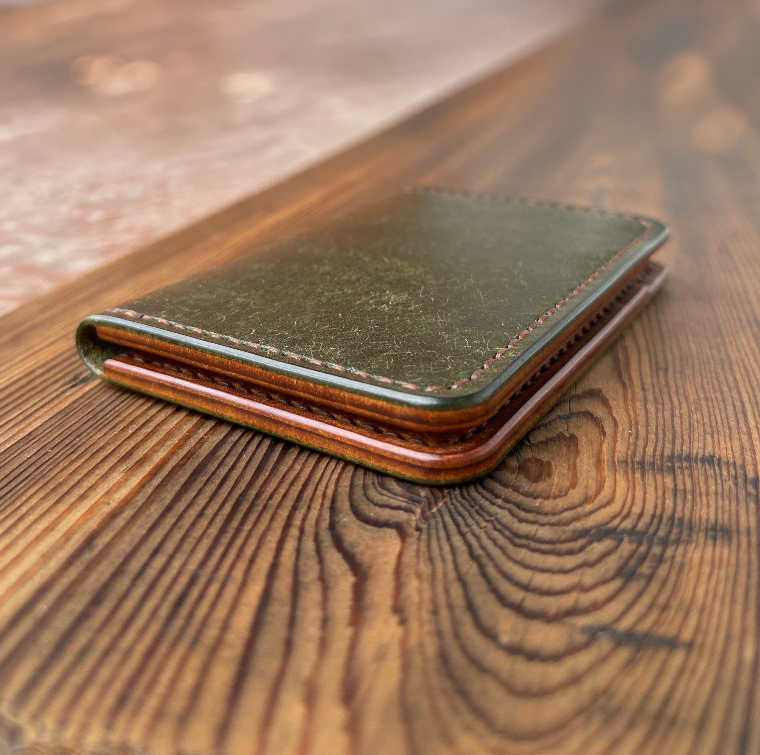 Green leather wallet on a wooden surface