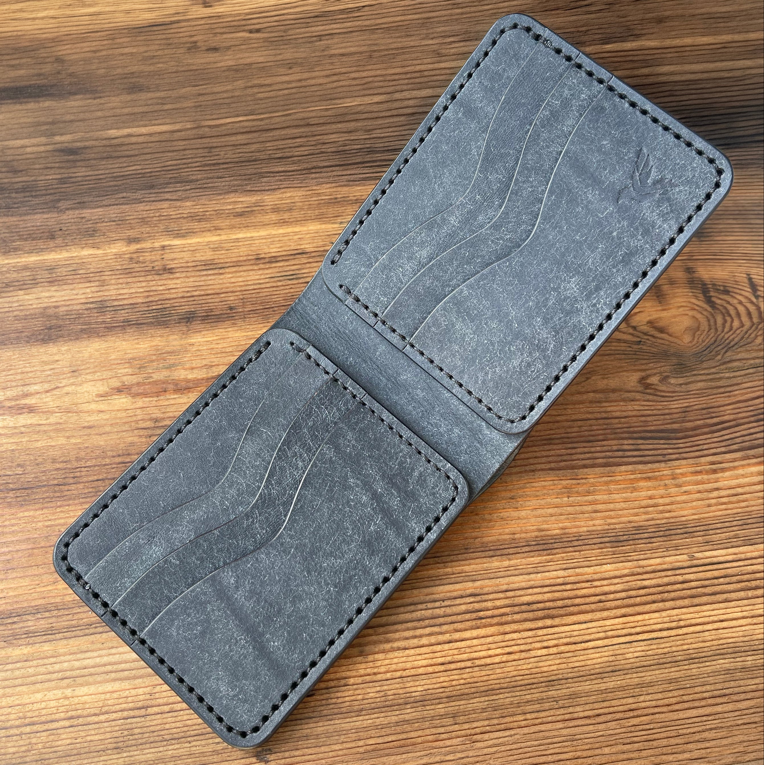 Gray leather wallet on a wooden surface