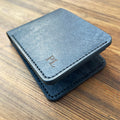 Blue leather wallet with a brand logo on a wooden surface