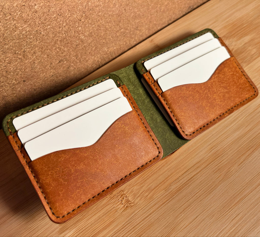 Two leather card holders with white cards on a wooden surface