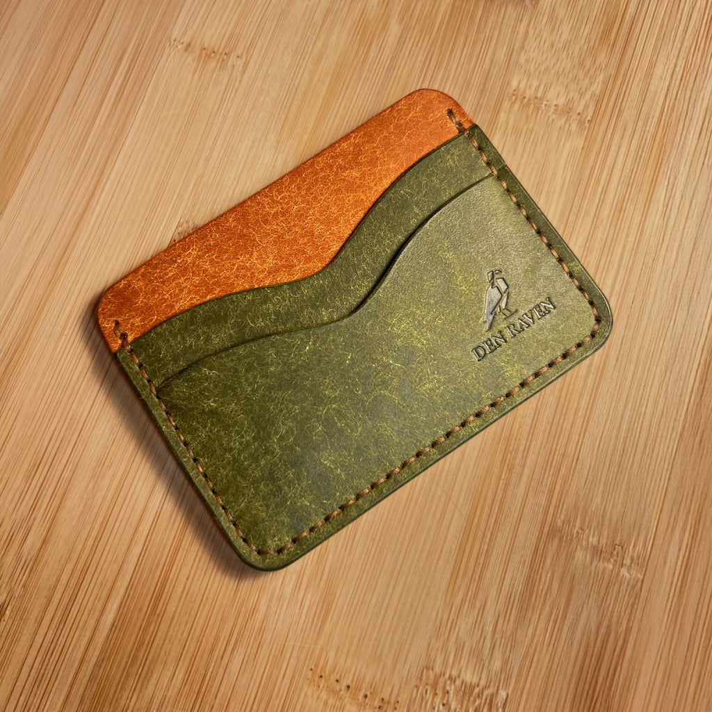 Two-tone leather cardholder on a wooden surface