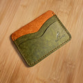 Two-tone leather cardholder on a wooden surface