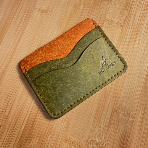 Two-tone leather cardholder on a wooden surface