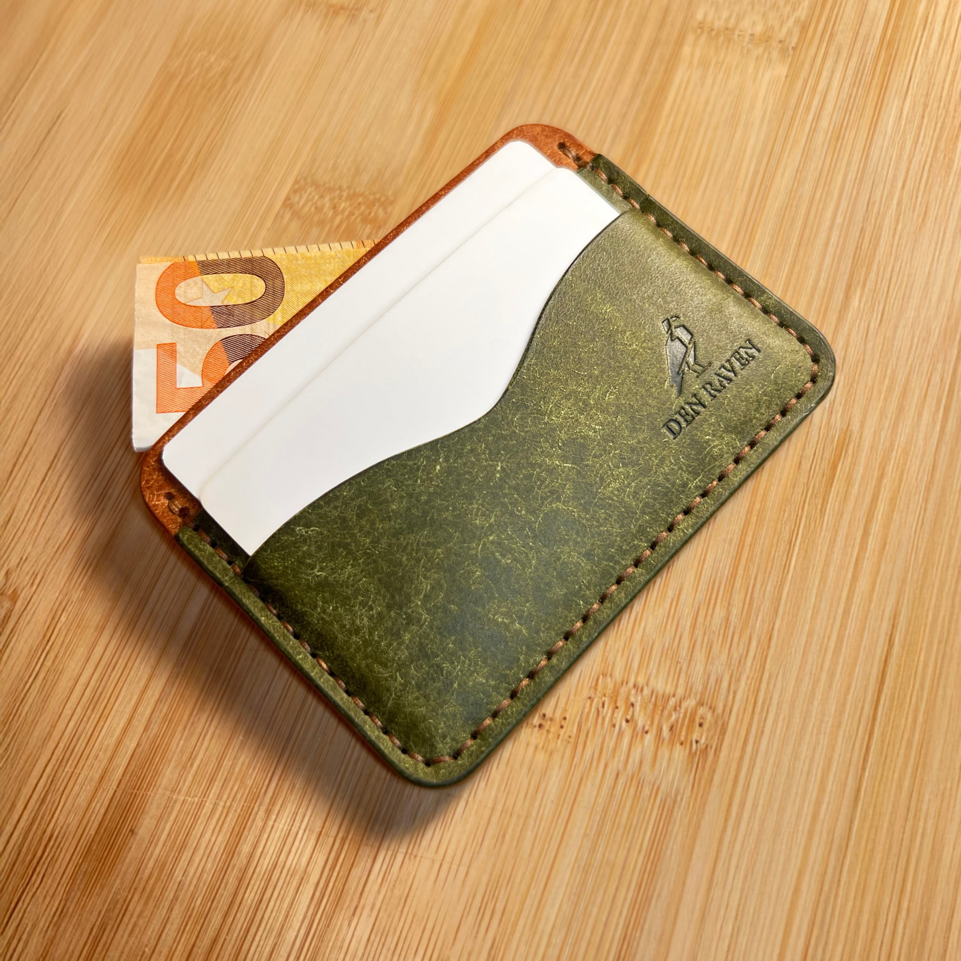 Green leather wallet with card slots on a wooden surface