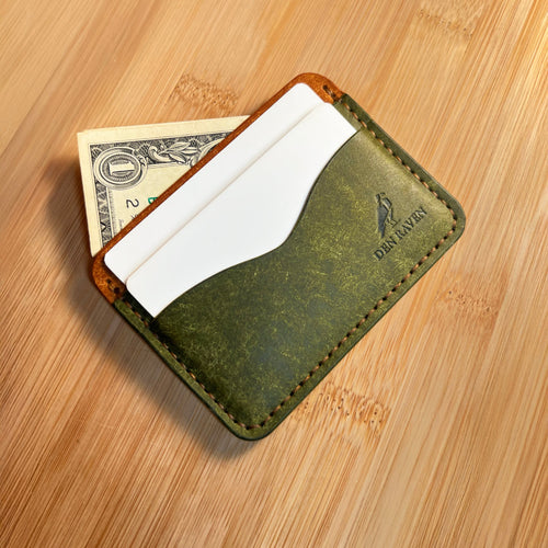 Green leather wallet with money and cards on a wooden surface