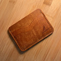 Brown leather wallet on a wooden surface