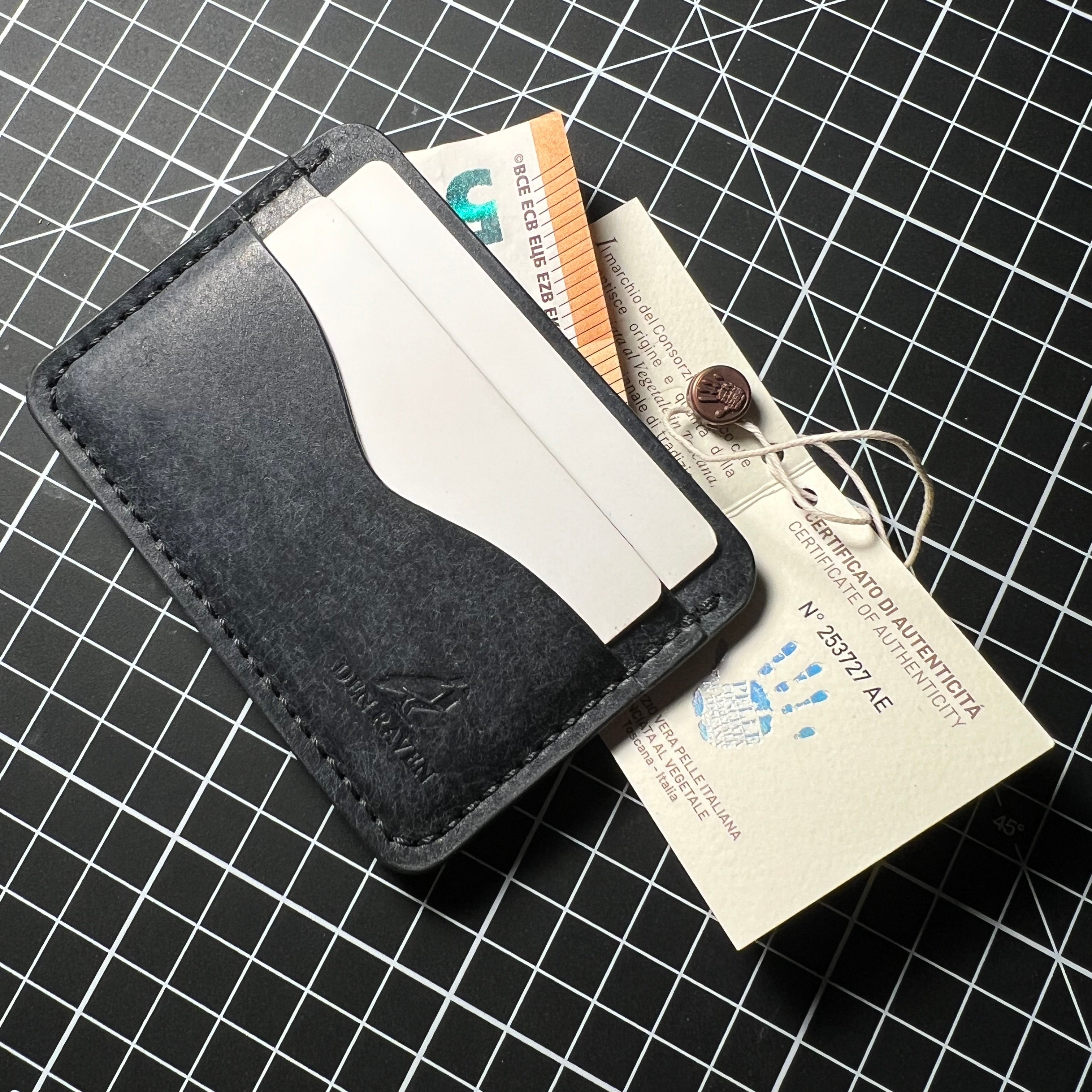 Black leather wallet with cards on a grid background