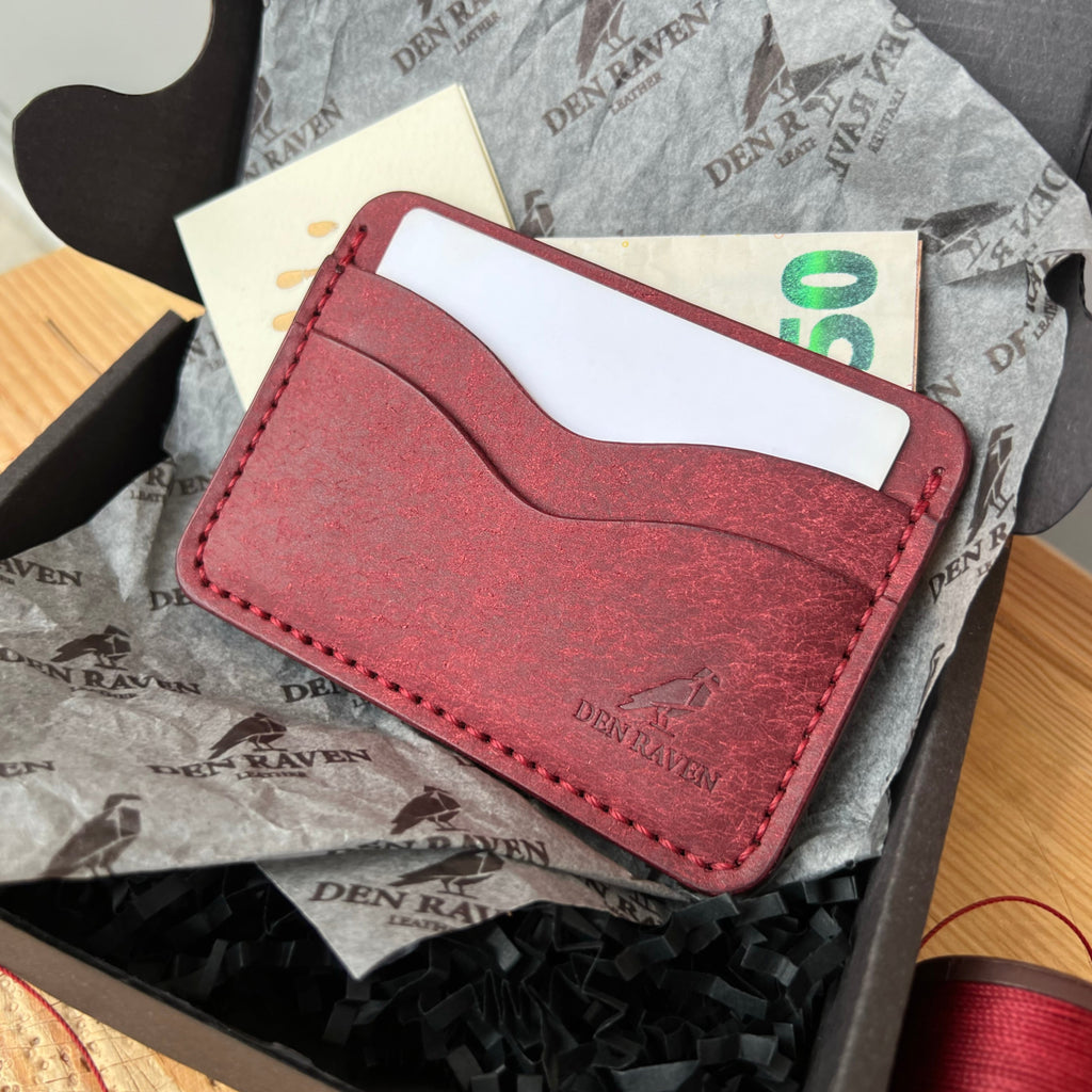 Red leather wallet with a card and money on a branded box