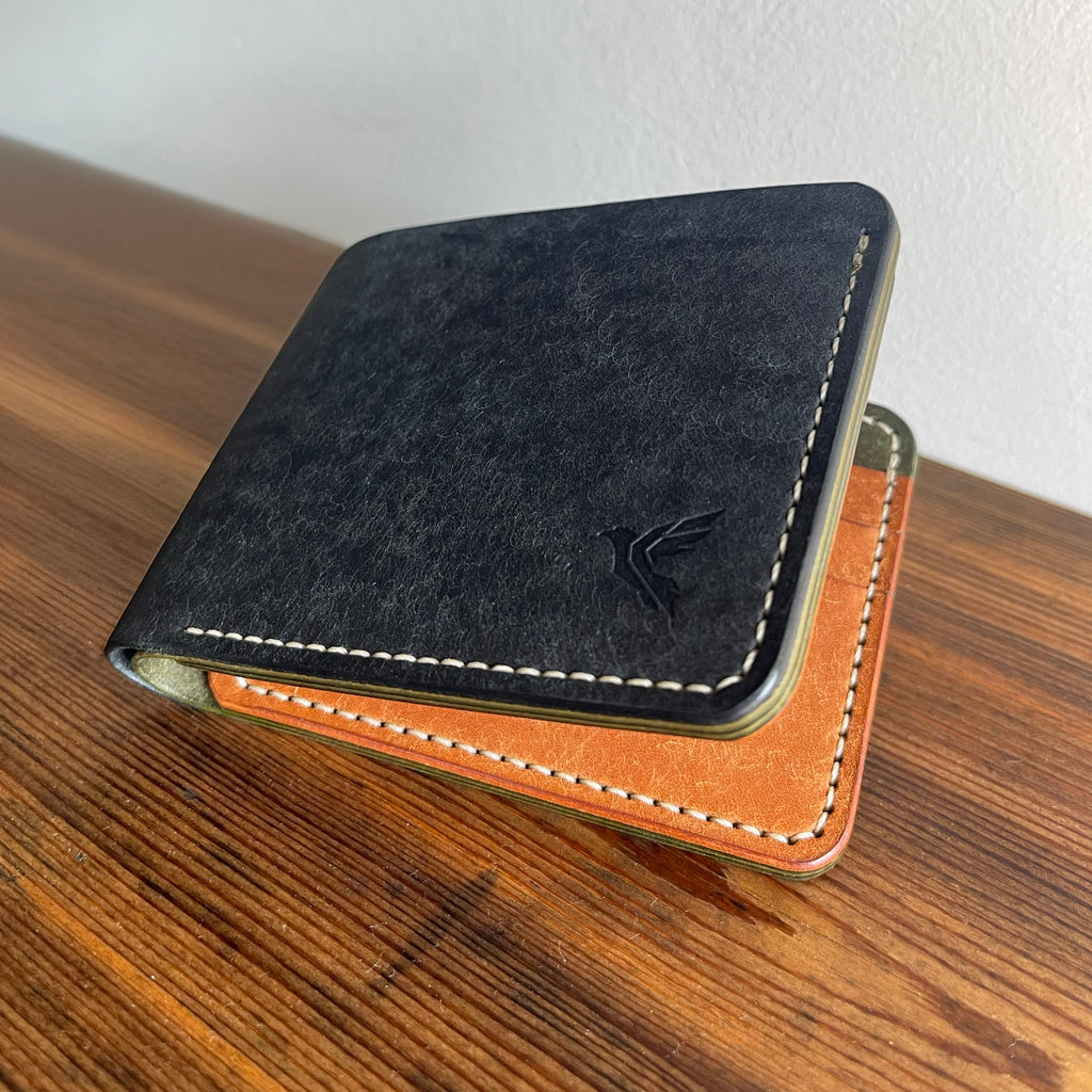 Two leather wallets, one black and one brown, on a wooden surface with a white background.