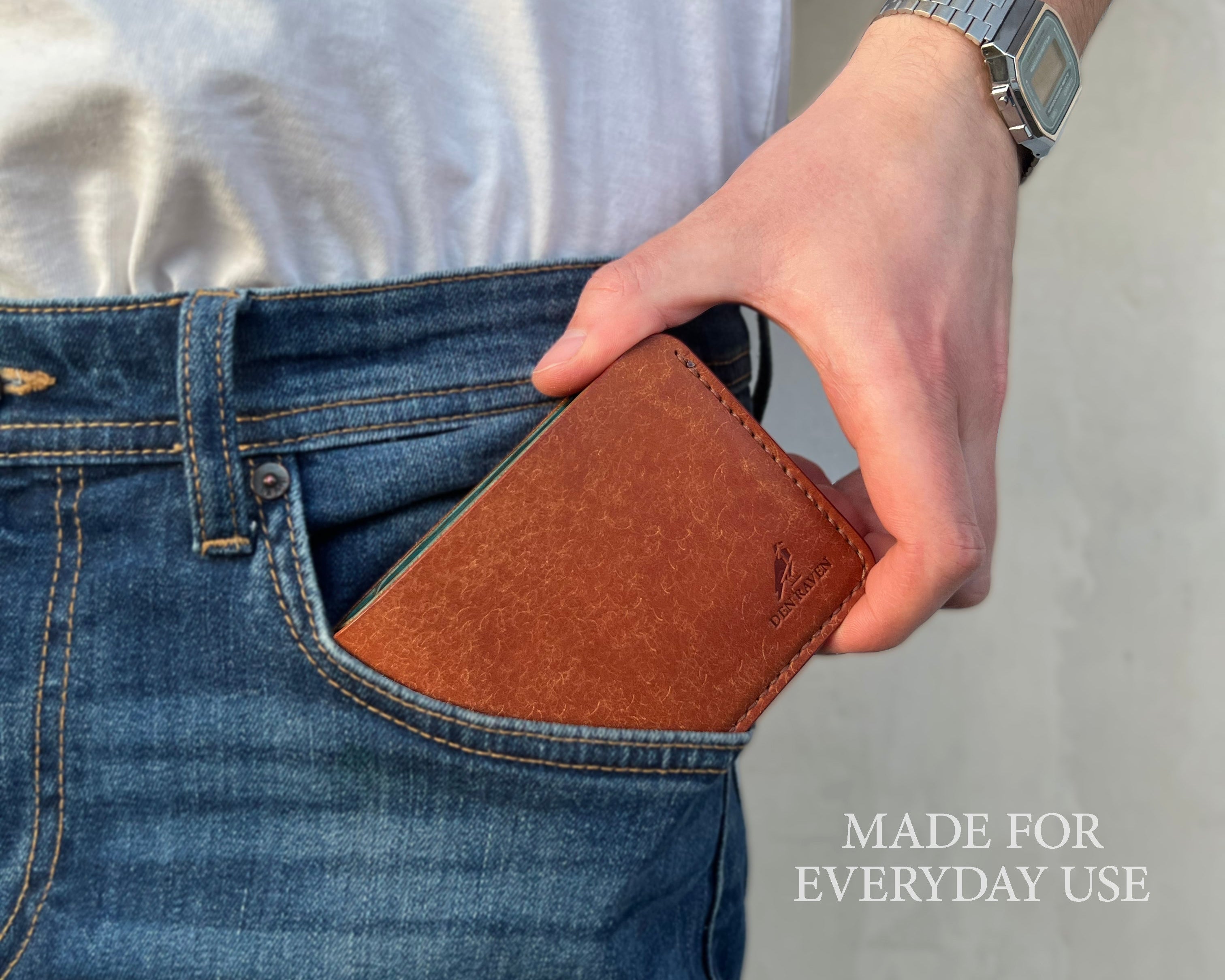 Person placing a brown wallet into their jeans pocket with text 'MADE FOR EVERYDAY USE'.
